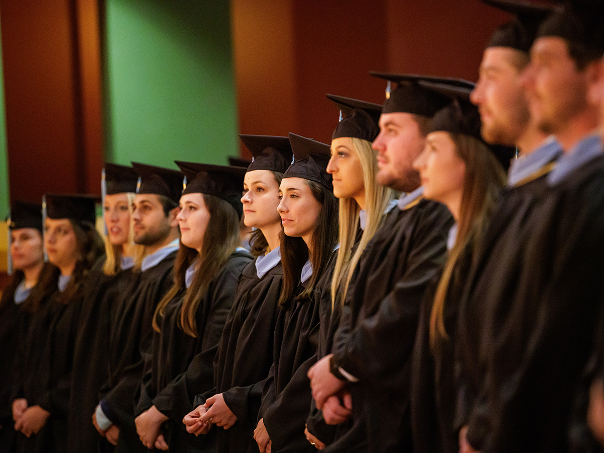 ACE graduates standing to listen to invocation.