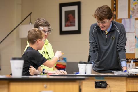 ACE Teacher Aidan Anderson (Right) working with students on a science experiment