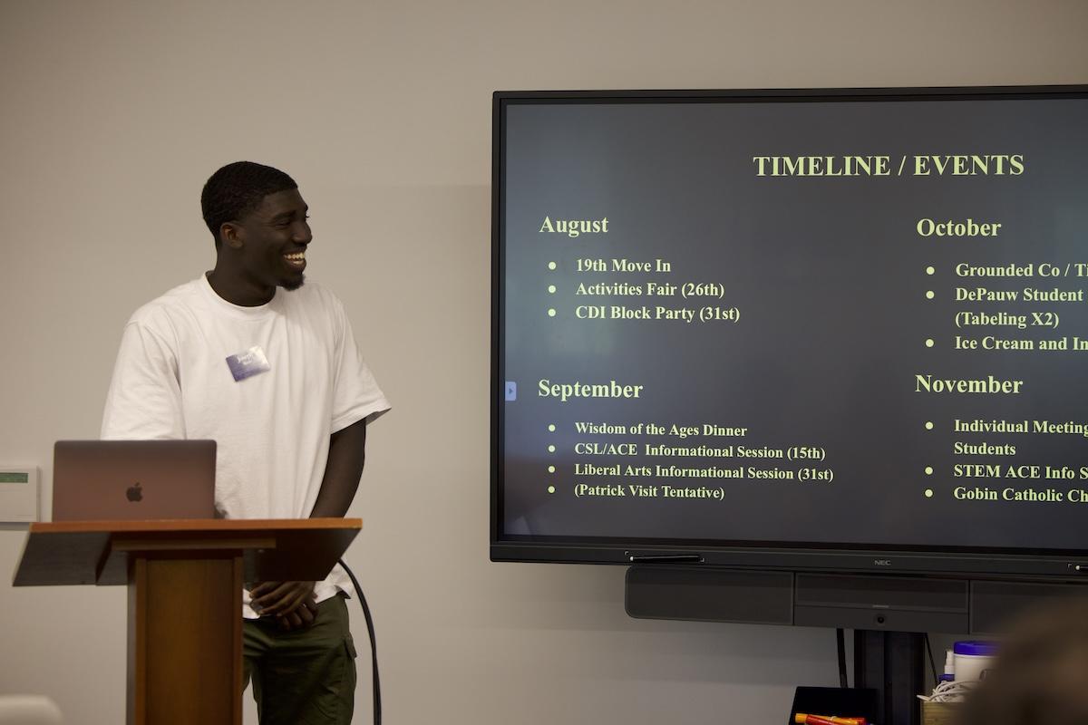 Joseph Baah smiling to someone off camera while presenting at Early Commit Institute